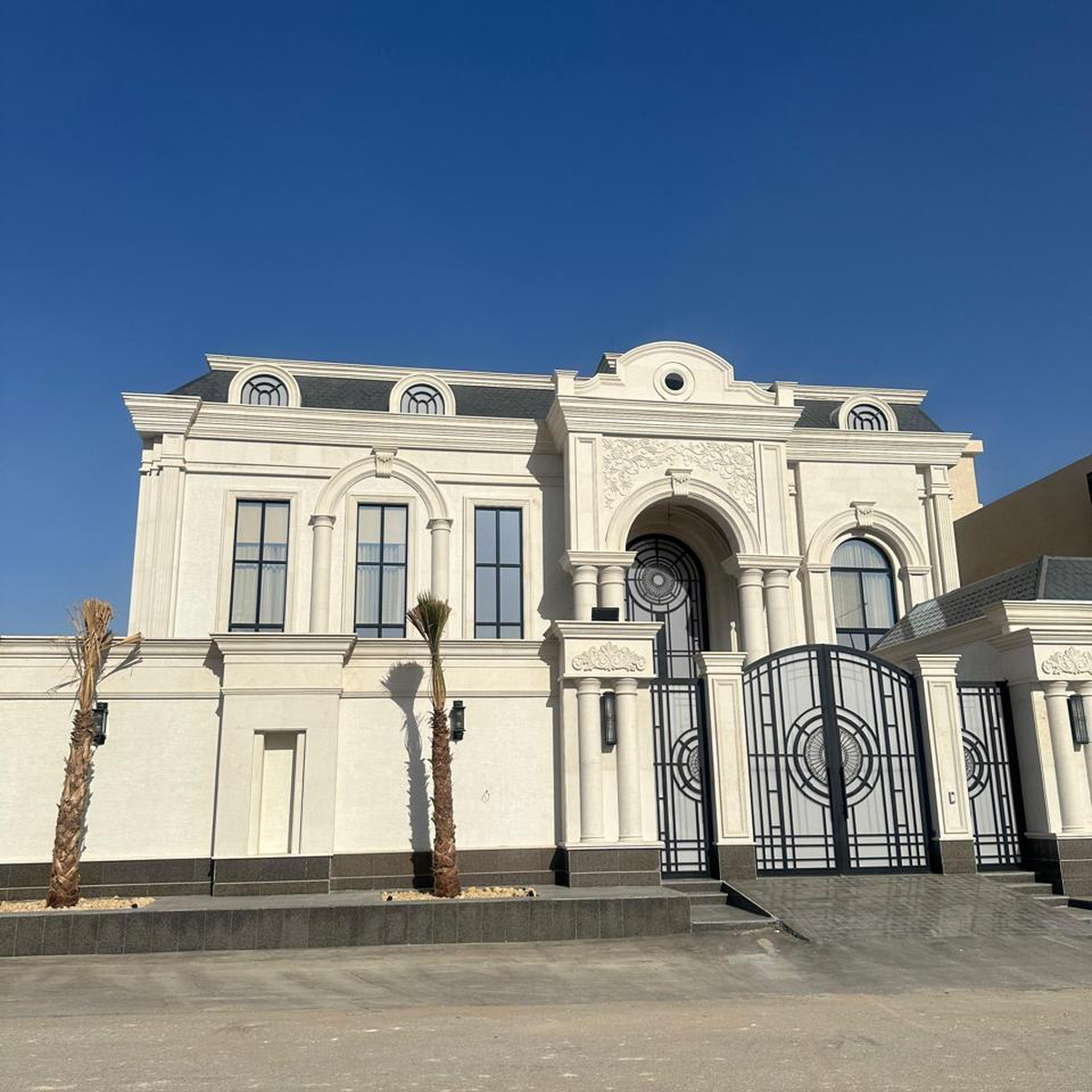 تشطيب قصر كلاسيك بمدخل مقوس وبوابة حديد وواجهة حجرية في الرياض