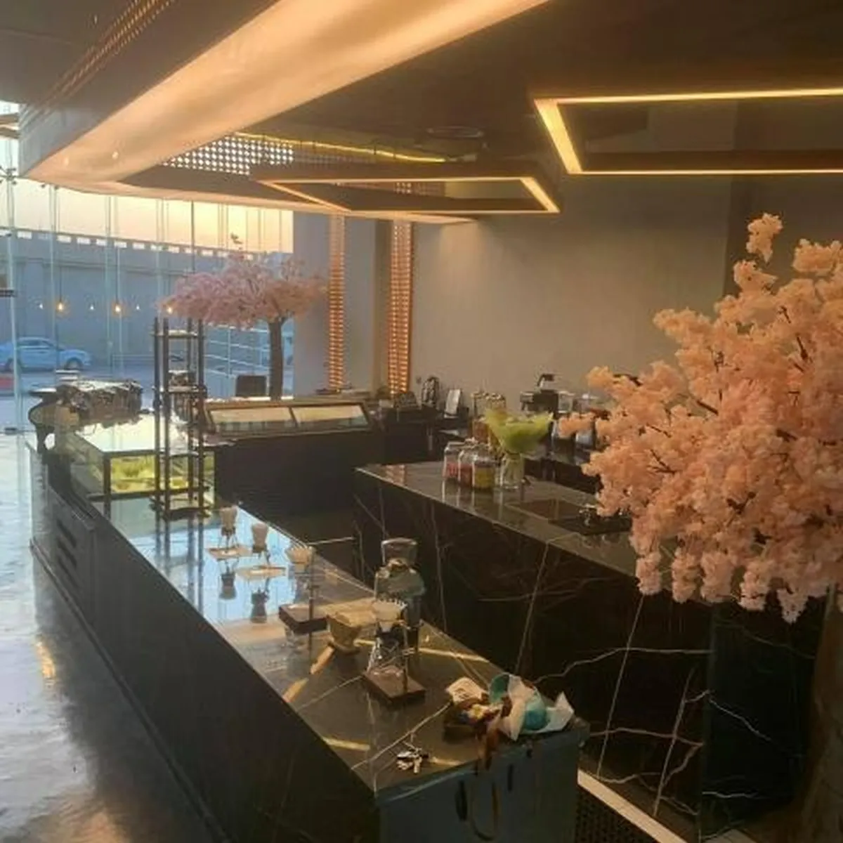 تشطيب مطعم بكاونتر رخامي طويل وبوفيه وسقف إضاءة هندسية في الرياض